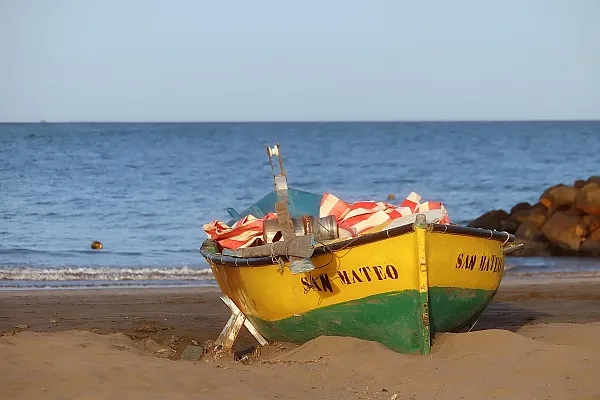 Auf dem Bild ist ein traditionelles Fischerboot am Strand von Gran Canaria zu sehen.