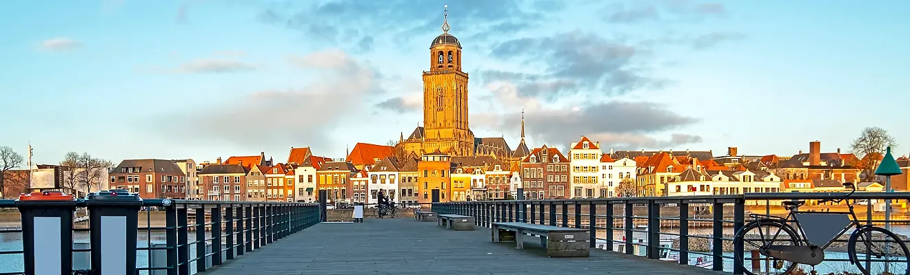 Das Bild zeigt die historische Hansestadt Deventer in den Niederlanden, gesehen von der anderen Seite des Flusses IJssel.