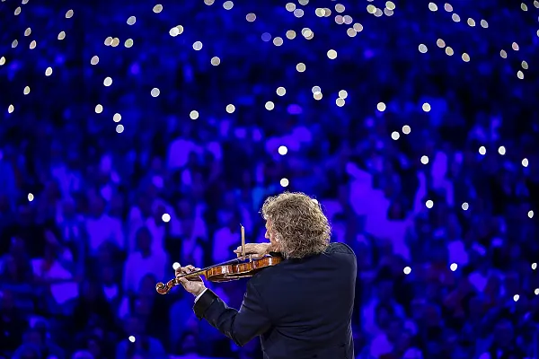 Das Bild zeigt den weltberühmten niederländischen Geiger und Dirigenten André Rieu während eines Konzerts. Er ist bekannt als der „König des Walzers“ und tritt oft zusammen mit seinem Johann Strauss Orchester auf.