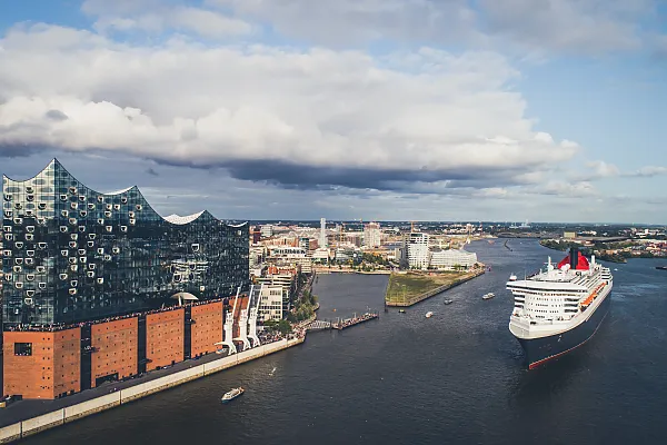 Dieses Foto zeigt einen besonderen Moment im Hamburger Hafen, an dem die Elbphilharmonie und das Kreuzfahrtschiff Queen Mary 2 gemeinsam zu sehen sind.