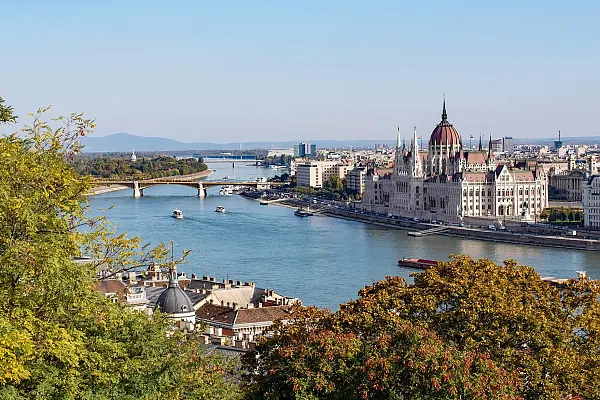 Das Bild zeigt das Ungarische Parlamentsgebäude in Budapest, wie es am Ufer der Donau liegt.