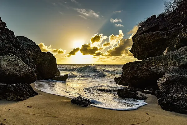 Das Bild zeigt einen malerischen Sonnenuntergang an einem Strand auf der Karibikinsel Curaçao, wahrscheinlich in der Nähe von Playa Guepi.