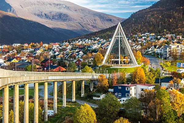 Das Bild zeigt die Eismeerkathedrale (Ishavskatedralen) in Tromsø, Norwegen, mit der markanten Tromsø-Brücke im Vordergrund.